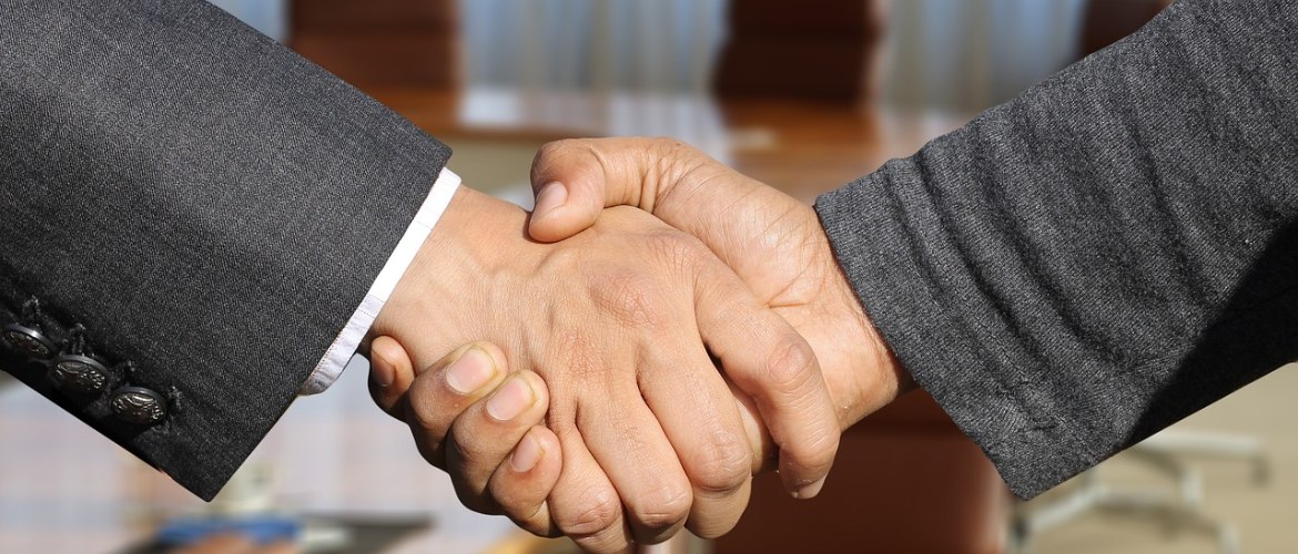  Zwei Hände, die sich die Hand geben. 