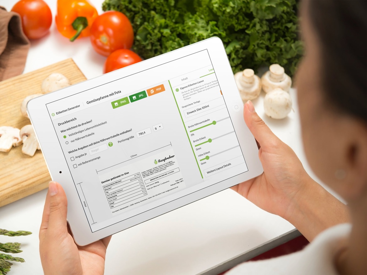 Die Benutzeroberfläche des Rezeptrecherns auf einem iPad. Im Hintergrund befindet sich Gemüse und ein Schneidebrett.
