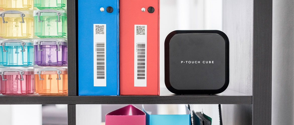 Brother Beschriftungsgerät auf einem Regal neben markierten Dateiordnern mit Barcodes