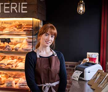 Frau mit Brauner Schürze im Café mit Sandwiches und TD-Etikettendrucker