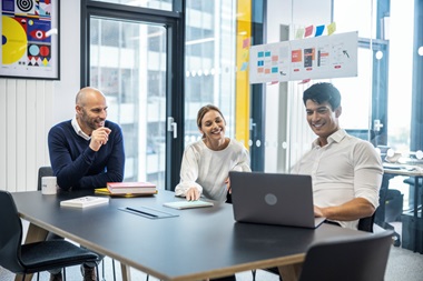 Drei Menschen in einem Meeting-Raum.