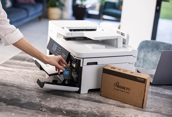 Frau, die eine Tintenpatrone in einen Drucker auf einem Tisch mit einer EcoPro-Box daneben einlegt