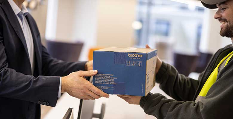 Ein Mann übergibt einem Paketboten ein Paket