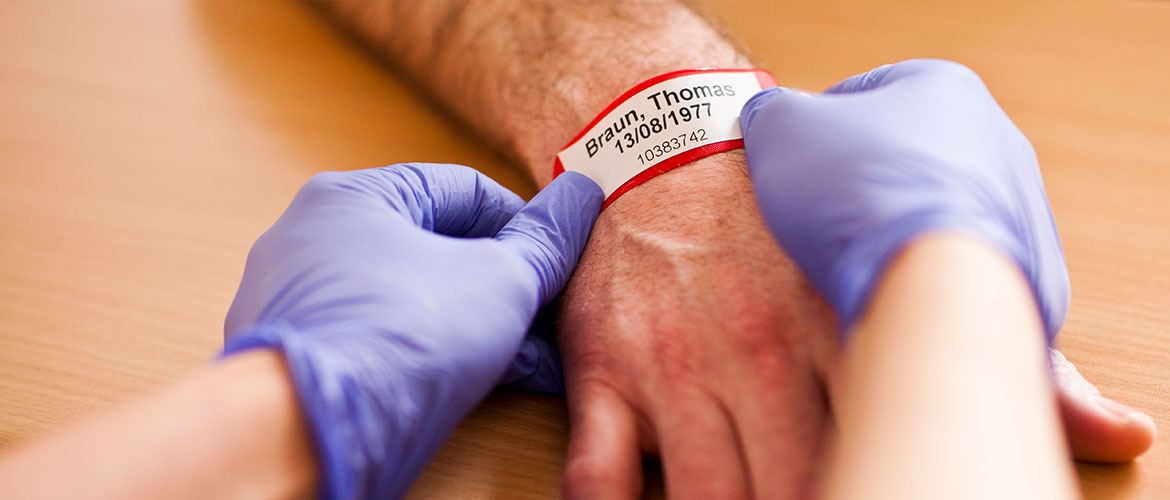 Krankenpfleger legt Patient ein Armband um
