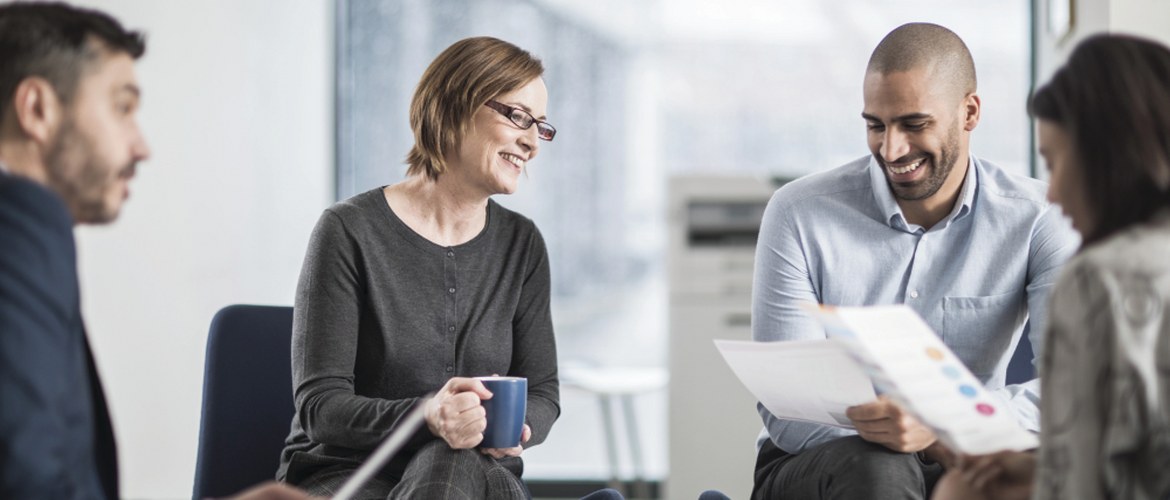 Vier Menschen sitzen im Büro beim Brainstorming.